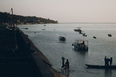 People on sea against clear sky