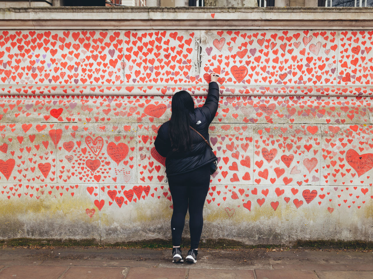 one person, red, full length, architecture, rear view, lifestyles, art, standing, adult, built structure, city, day, leisure activity, wall - building feature, wall, casual clothing, building exterior, women, young adult, clothing, outdoors, pattern