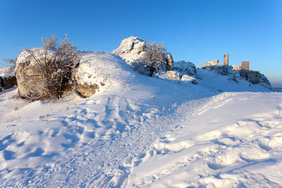 Scenic view of snow covered mountains against clear blue sky