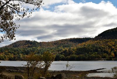 Scenic view of lake by mountains against sky