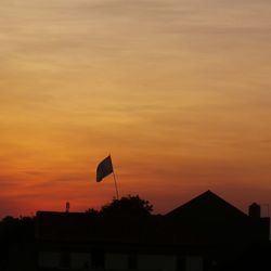 Silhouette building against dramatic sky during sunset