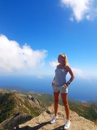 Woman standing on mountain against sky