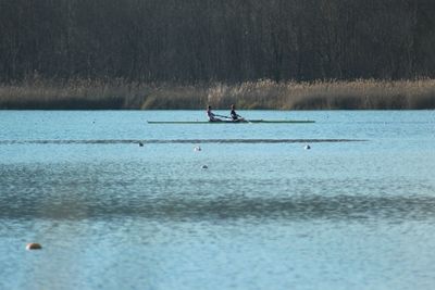 People rowing boat in lake