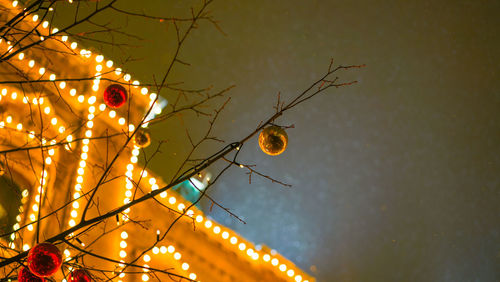 Low angle view of illuminated christmas lights against sky at night