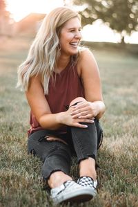 Smiling young woman sitting on field