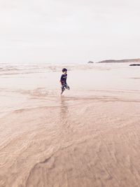 Full length of boy running on beach