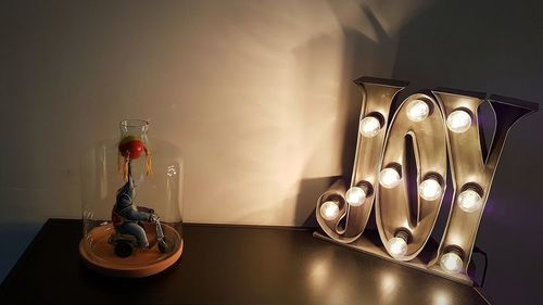 Close-up of illuminated lamp on table at home