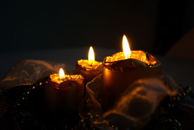 Close-up of illuminated diyas in darkroom