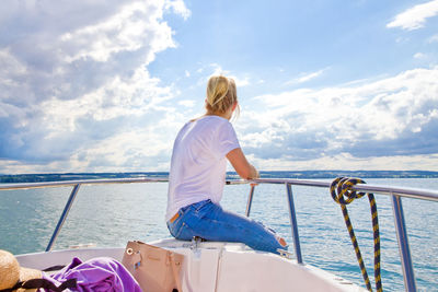 Side view of woman in boat on sea against sky