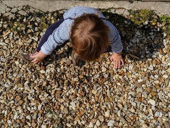 High angle view of boy on pebbles