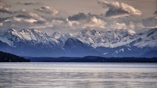 Scenic view of lake and snowcapped mountains against sky