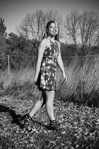 Full length portrait of woman standing on field