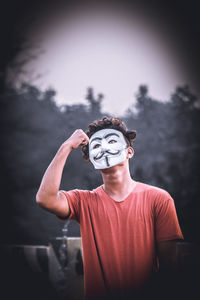 Young man flexing muscles while wearing mask