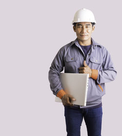 Man wearing hat standing against white background