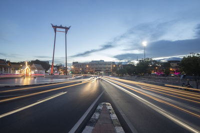 Light trails on highway in city against sky