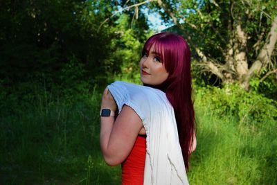 Portrait of a beautiful young woman standing on land