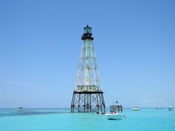 Sailboat in sea against clear blue sky