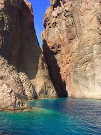 Scenic view of rock formation in sea against sky