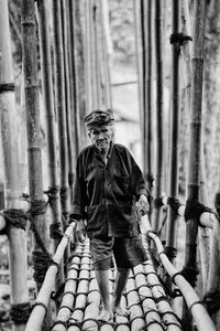 Full length of senior man walking on bamboo footbridge