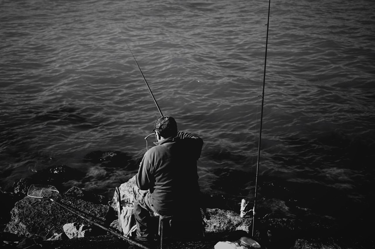 water, men, fishing, lifestyles, sea, leisure activity, nautical vessel, fishing rod, standing, rippled, nature, high angle view, rope, outdoors, lake, rear view, river, day