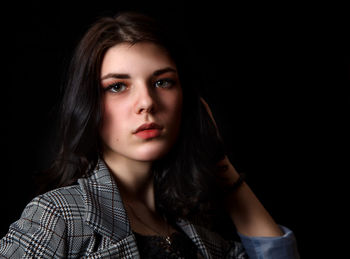 Portrait of a beautiful young woman over black background