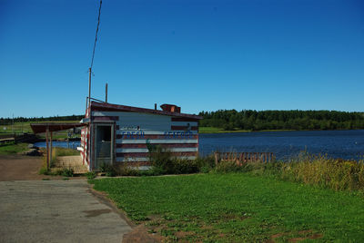 Built structure on field against clear blue sky