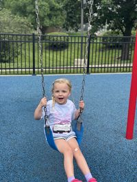 Portrait of boy swinging at playground