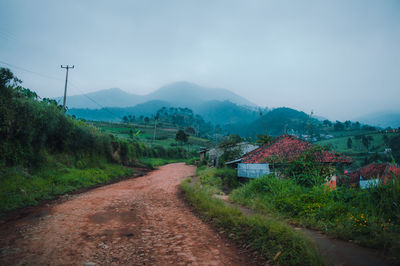 Road leading towards mountains against sky