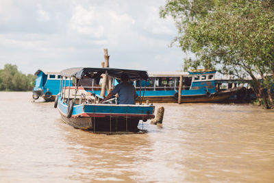 Rear view of man in boat on river