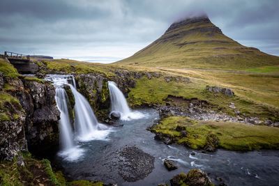 Scenic view of waterfall against sky