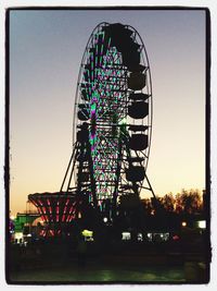 Low angle view of illuminated ferris wheel at night