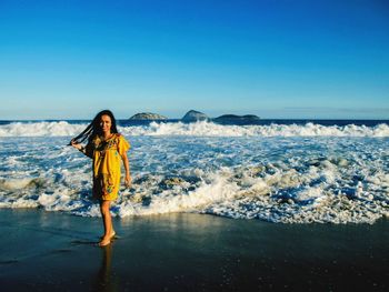 Woman on beach against clear blue sky