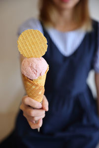 Midsection of woman holding ice cream cone
