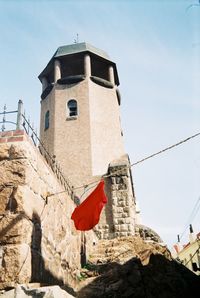 Low angle view of flags on building against sky