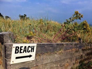 Information sign on land against sky