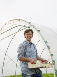 Portrait of smiling man standing against sky