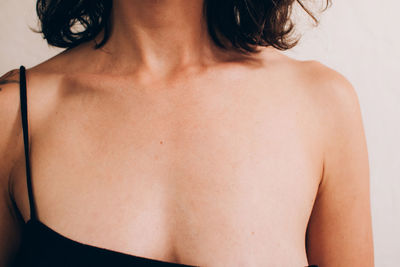 Rear view of shirtless woman against wall