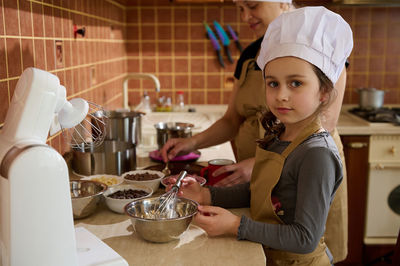Portrait of smiling girl preparing food at home