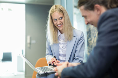 Portrait of young woman using digital tablet in office