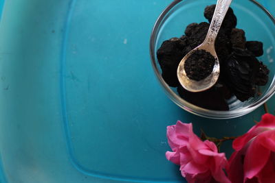 Directly above shot of coal by pink flowers on table