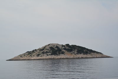 Scenic view of sea and mountain against clear sky