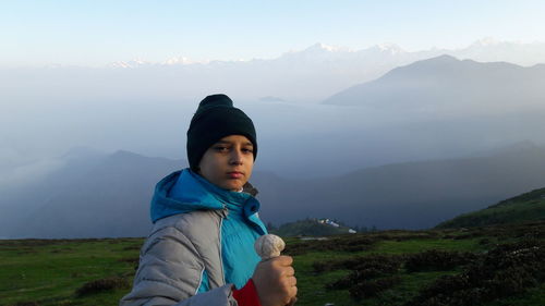 Portrait of teenage boy standing on himalayas during foggy morning