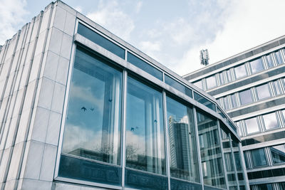 Low angle view of glass building against sky