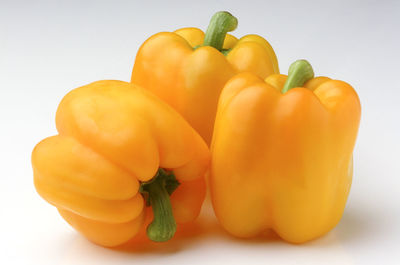 Close-up of yellow bell peppers against white background