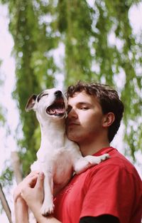 Portrait of young man holding dog