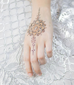 Midsection of woman with tattoo on bed