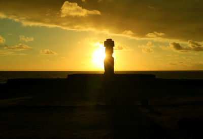 Silhouette man standing by sea against sky during sunset