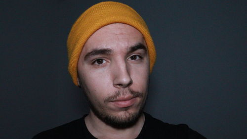 Portrait of young man against black background