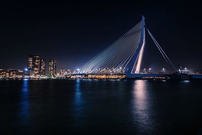 Illuminated bridge over river at night