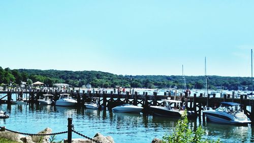 Boats moored in river against clear sky